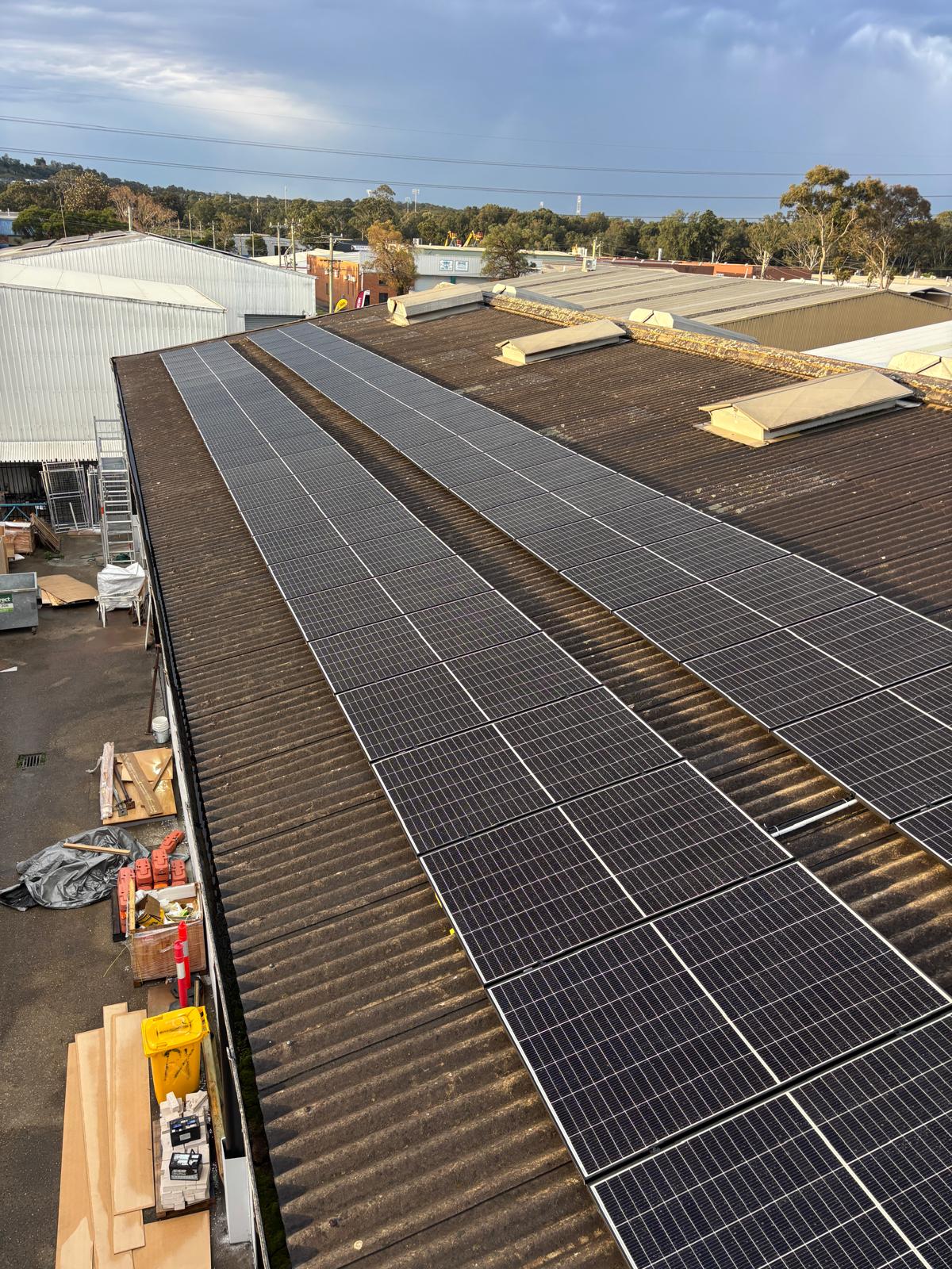 Long rows of solar panels on a commercial metal roof.